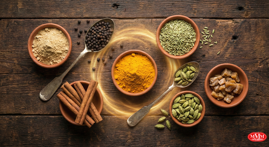 Assorted Indian spices like turmeric, cardamom, cinnamon, fennel, and black pepper in clay bowls on wooden table