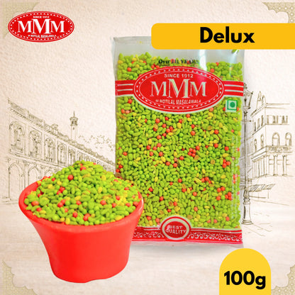 Packaged green spices with MMM branding and a red bowl filled with spices on a decorative background.